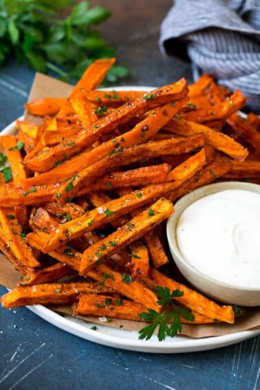 A plate of sweet potato fries with ranch dip on the side.