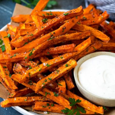 A plate of sweet potato fries with ranch dip on the side.
