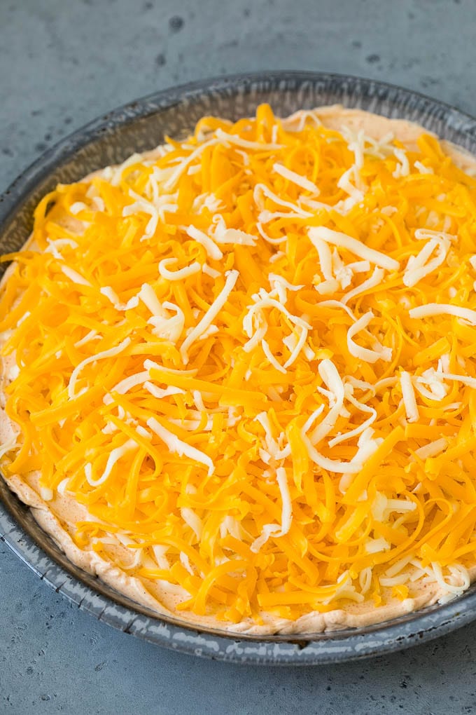 Shredded cheese sprinkled over taco flavored cream cheese and sour cream.
