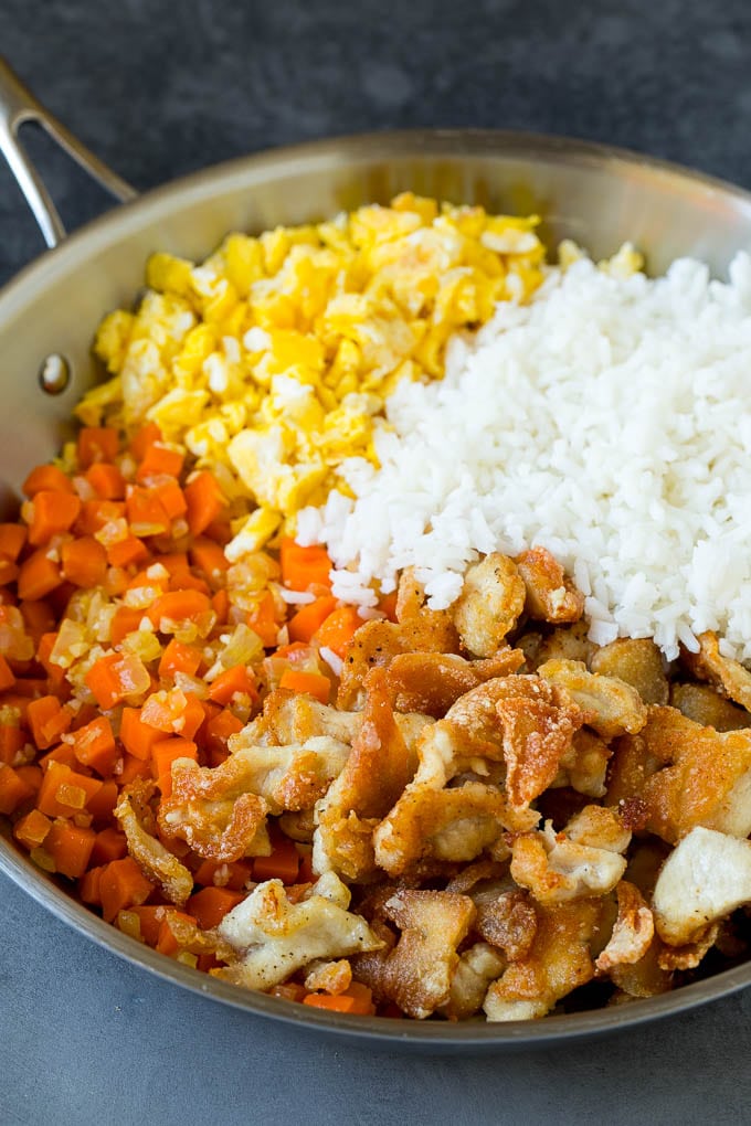 Cooked white rice with thinly sliced chicken, eggs and vegetables.