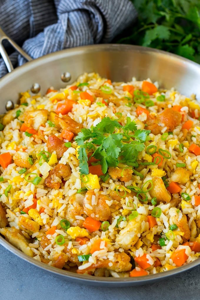 Thai fried rice in a skillet with chicken and mixed vegetables.