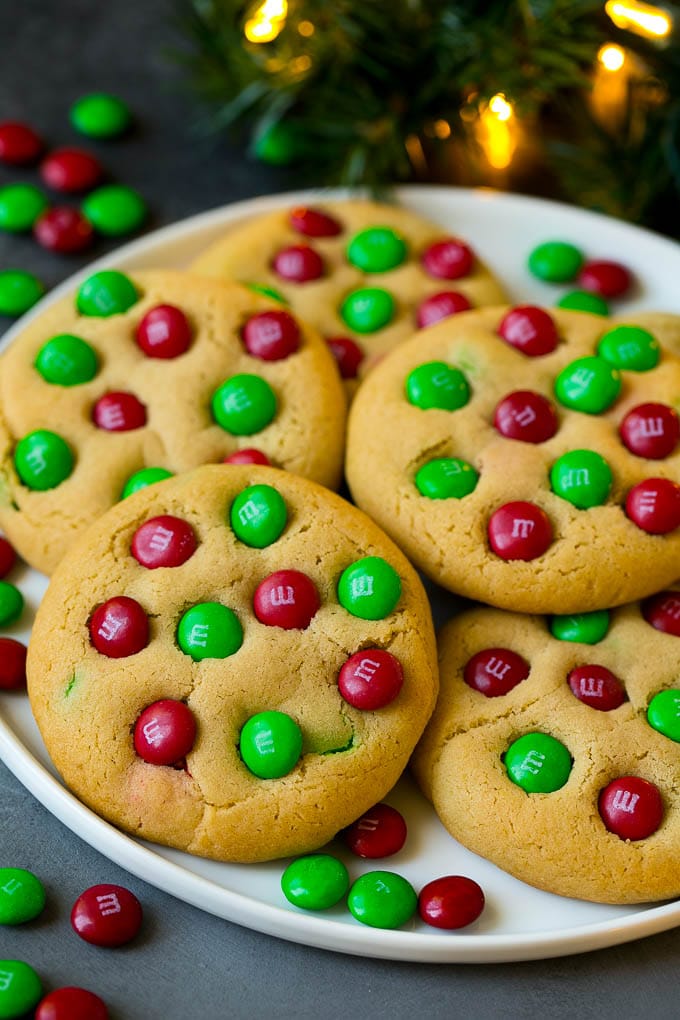 A plate of Christmas cookies with red and green M&Ms in them.