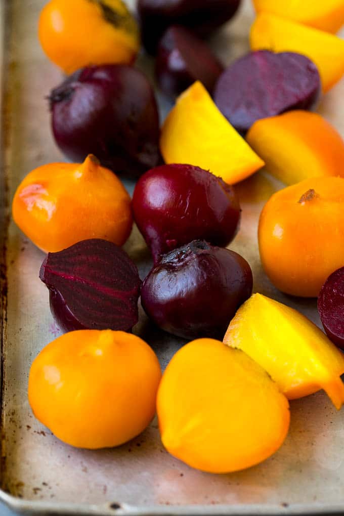 Roasted red and yellow beets on a sheet pan.