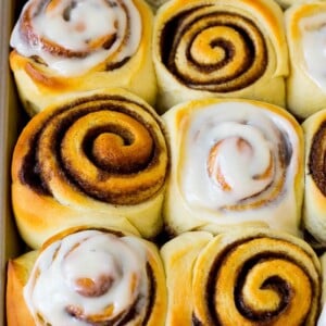 Homemade cinnamon rolls, some with frosting on top.