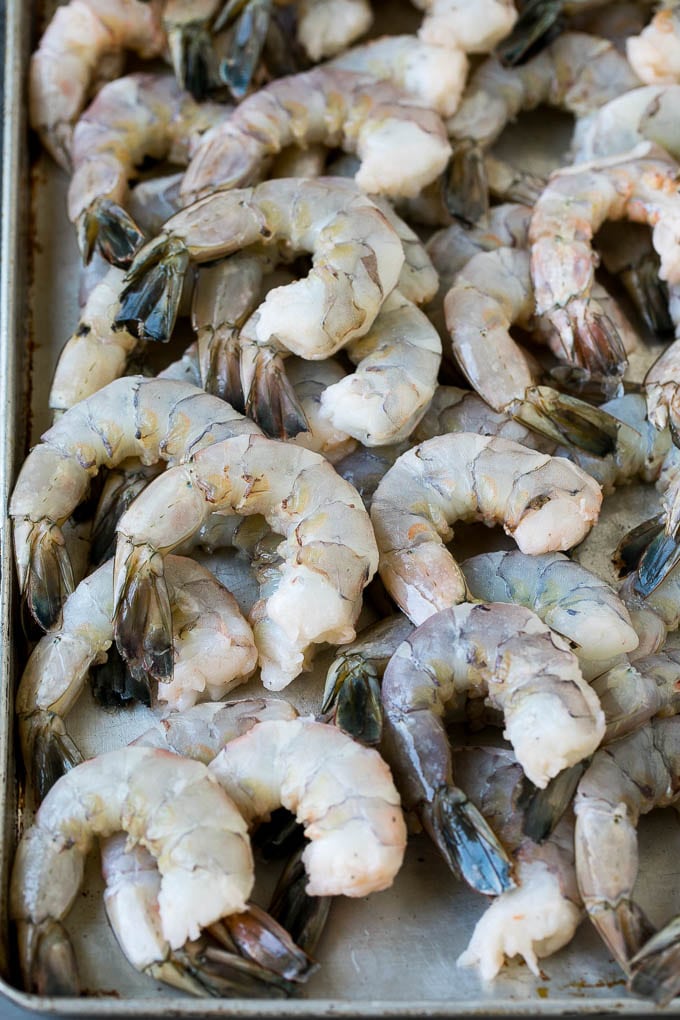 Raw shrimp on a sheet pan.