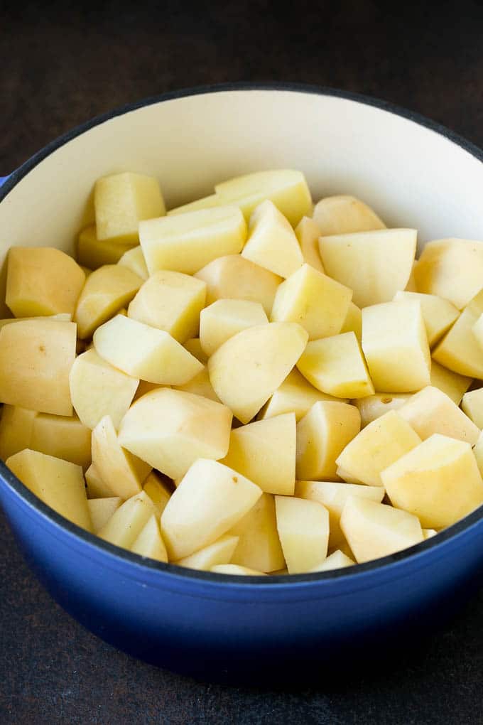 Diced potatoes in a large blue pot.