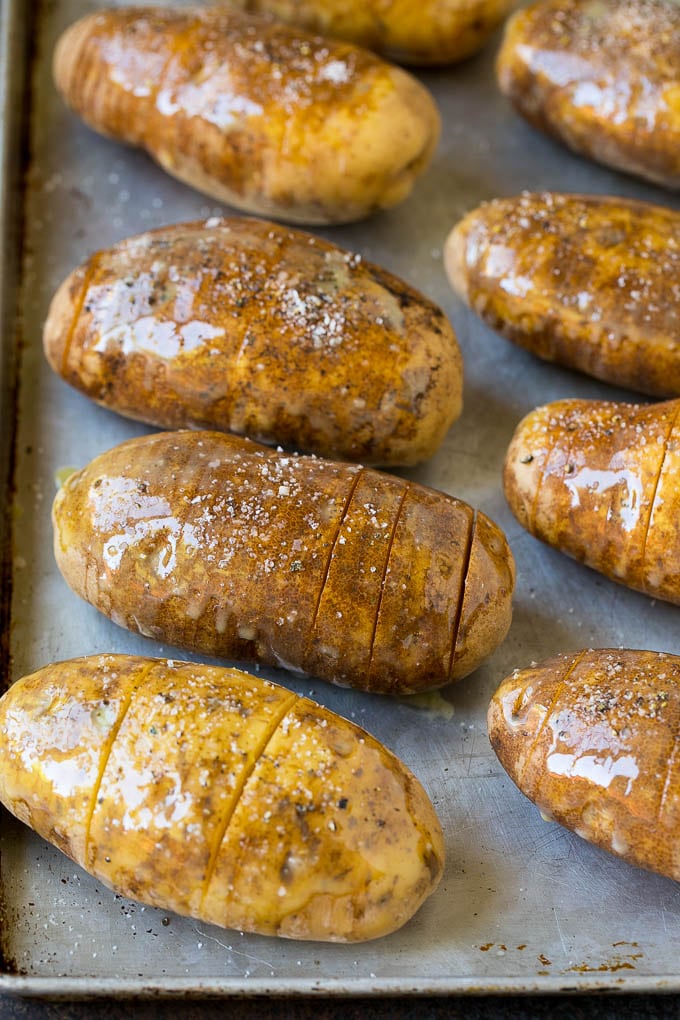 Potatoes on a sheet pan coated in olive oil and butter.