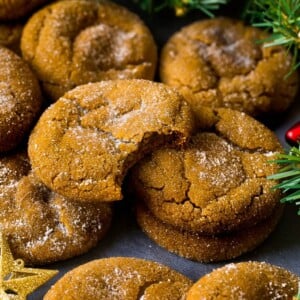 Molasses cookies coated in sugar, surrounded by holiday decorations.