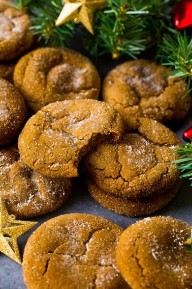 Molasses cookies coated in sugar, surrounded by holiday decorations.