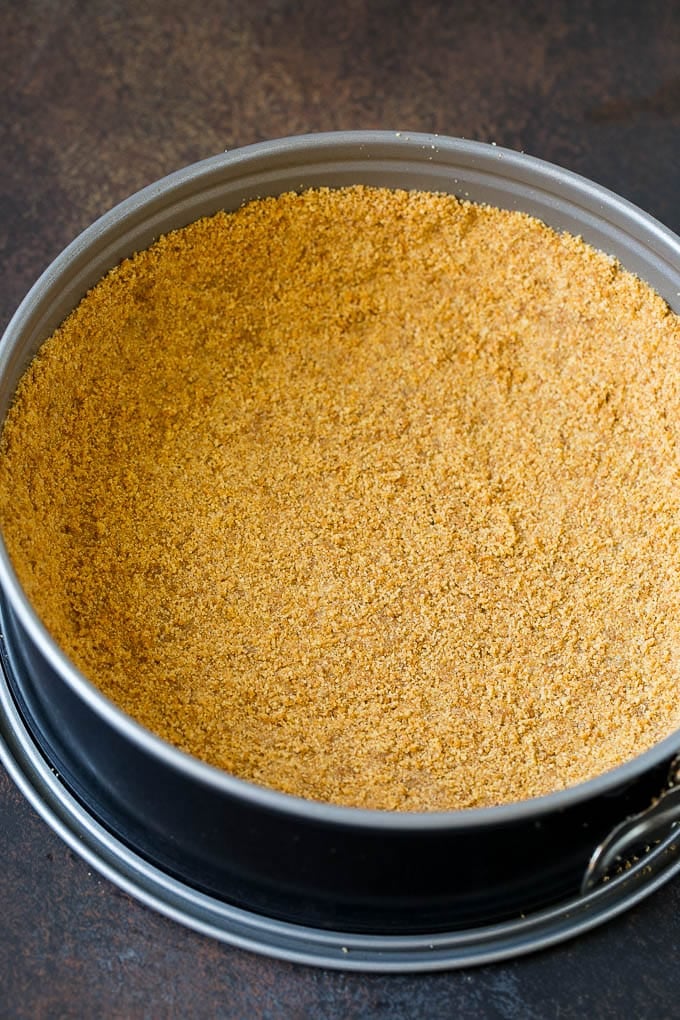 Graham cracker crust in a springform pan.