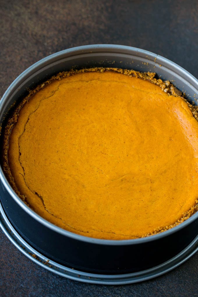 Pumpkin Pie Cheesecake Recipe | Pumpkin Cheesecake #cake #cheesecake #pumpkin #fall #thanksgiving #dessert #dinneratthezoo A baked pumpkin cheesecake in a pan.