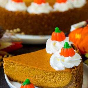 A slice of pumpkin pie cheesecake garnished with whipped cream.