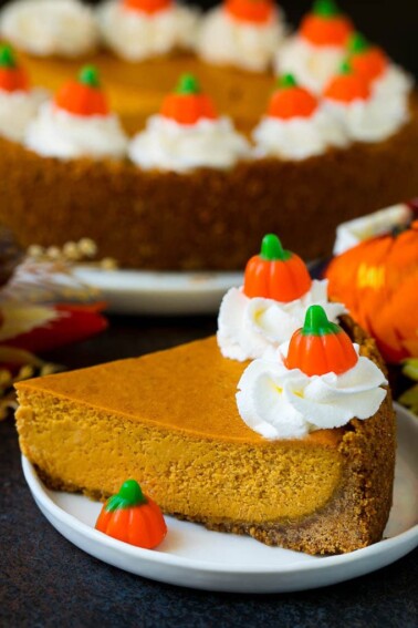 A slice of pumpkin pie cheesecake garnished with whipped cream.