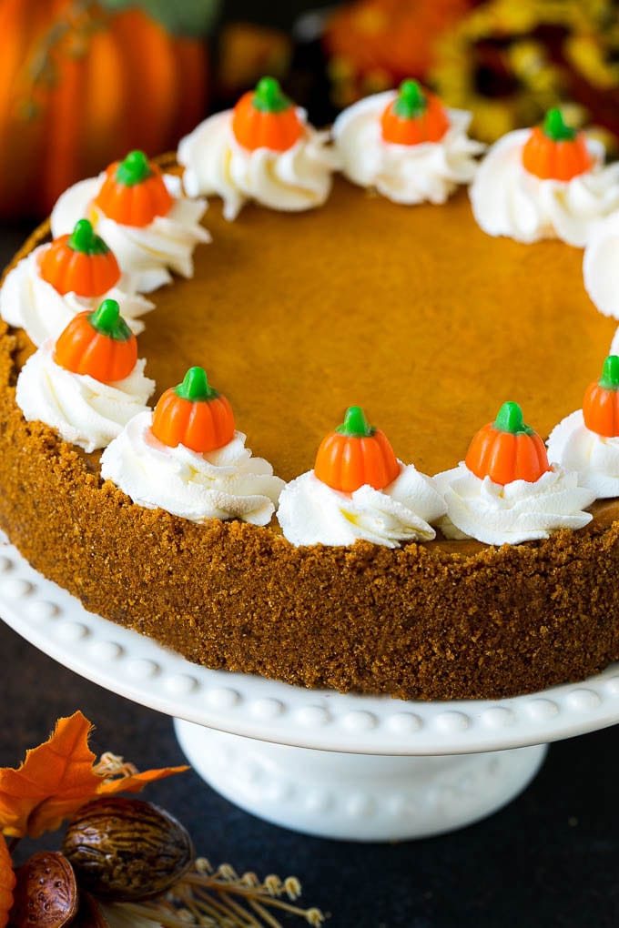 Pumpkin pie cheesecake topped with whipped cream and candy pumpkins.