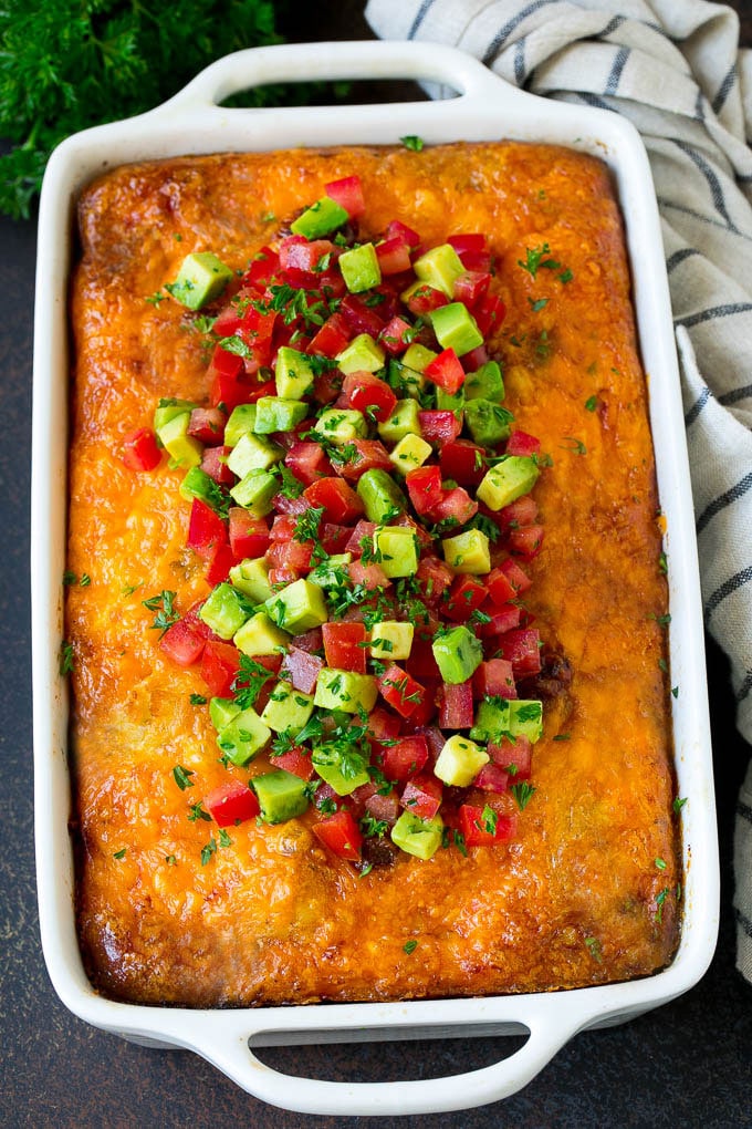 Sausage egg casserole topped with avocado and tomato.