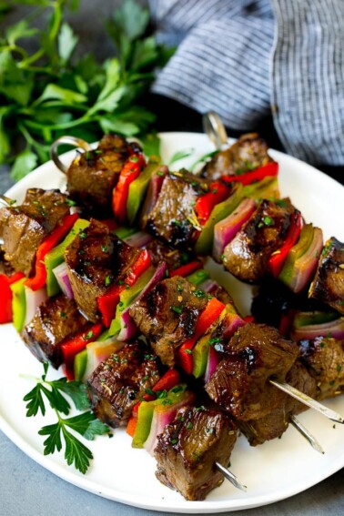 Shish kabob made with beef, peppers and onions on a serving plate.