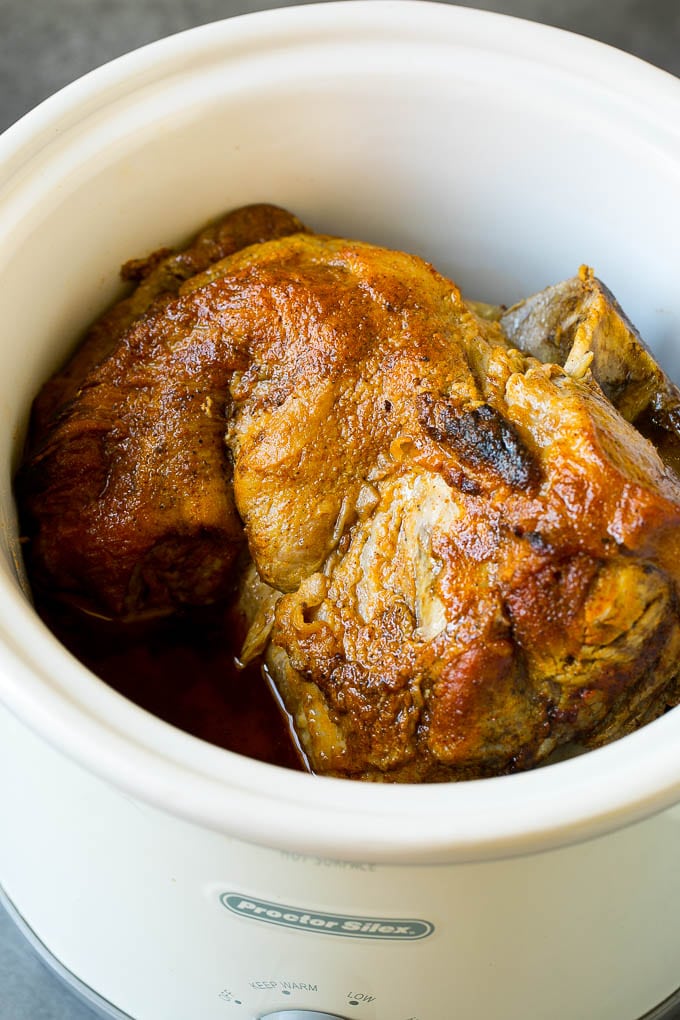 A pork roast inside of a crock pot.