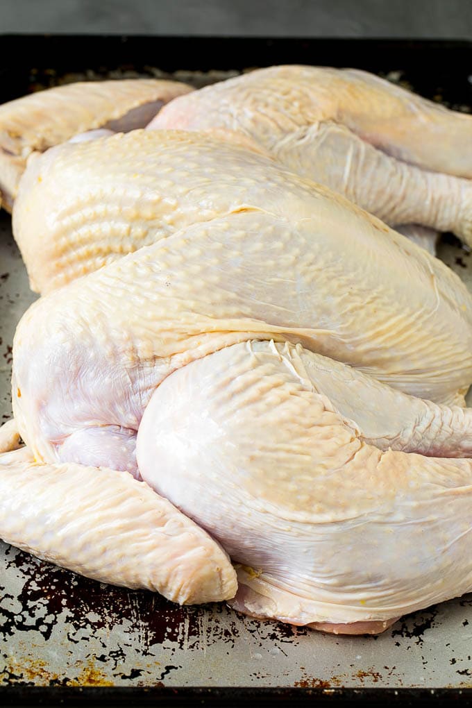 Spatchcock Turkey | Roasted Turkey | Thanksgiving Turkey #turkey #thanksgiving #dinner #fall #christmas #dinneratthezoo A flattened whole turkey on a sheet pan.