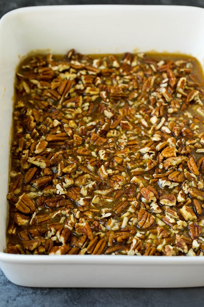 Caramel and pecans in the bottom of a baking dish.