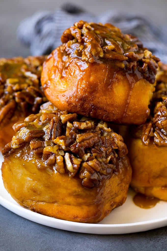 A plate of sticky buns topped with chopped nuts.