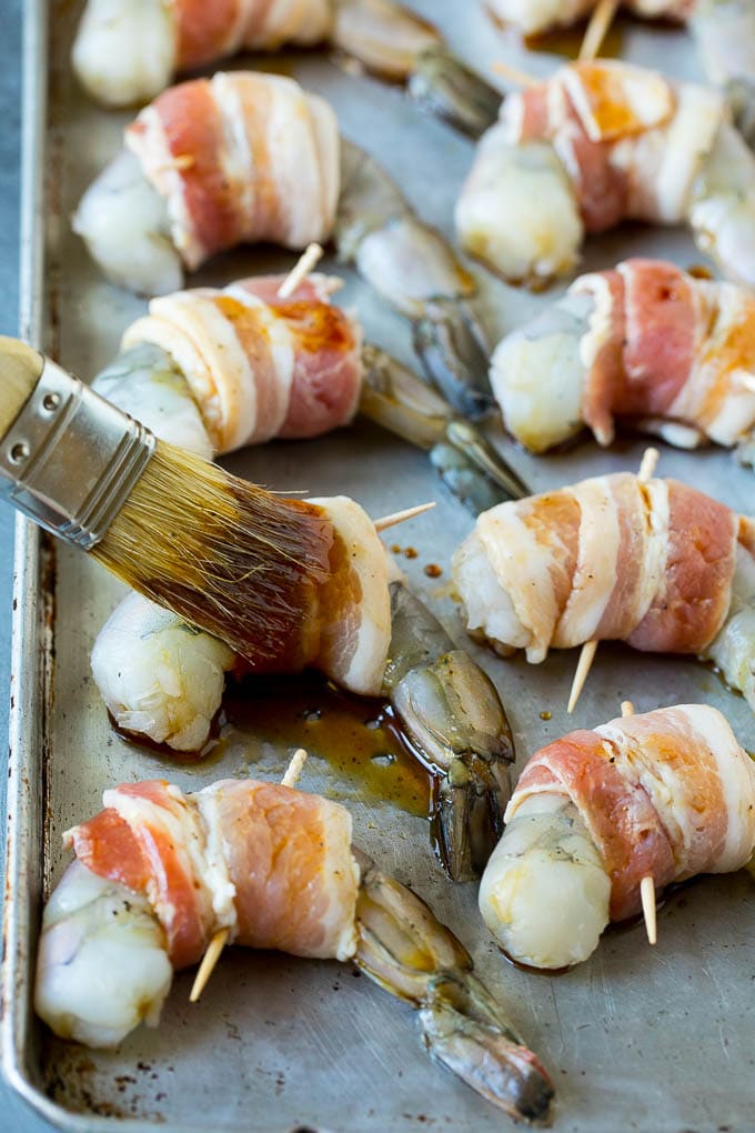 A basting brush applying sauce to shrimp.