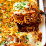 A spatula holding up a serving of baked spaghetti.