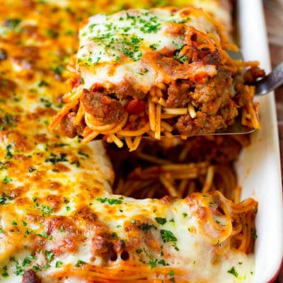 A spatula holding up a serving of baked spaghetti.