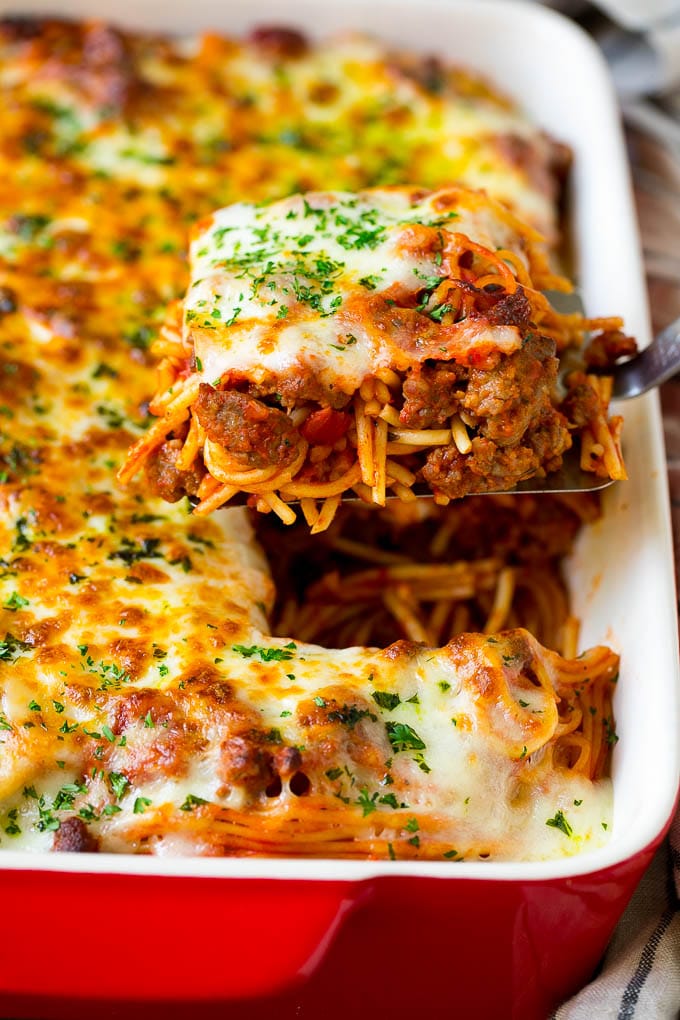 A spatula holding up a serving of baked spaghetti.