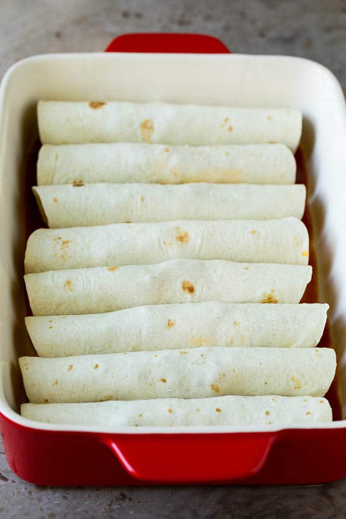 Flour tortillas wrapped around ground beef in a baking dish.