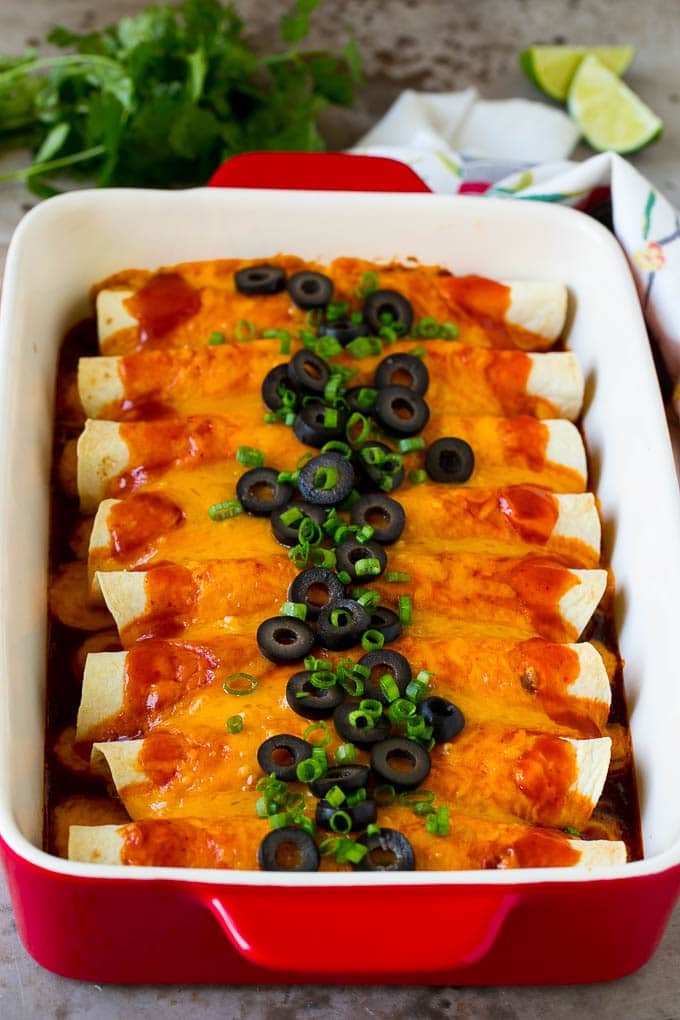 Beef enchiladas topped with melted cheese, olives and green onions.