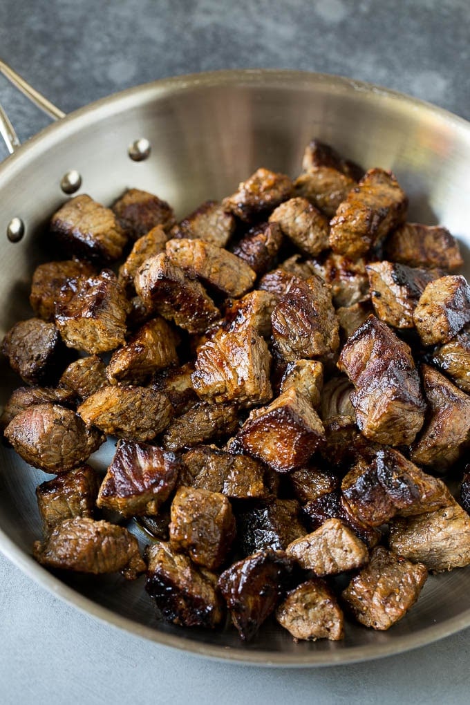 Seared pieces of sirloin steak in a frying pan.