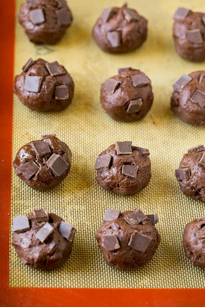 Brownie Cookies Recipe | Chocolate Cookies #cookies #brownies #chocolate #dessert #baking #dinneratthezoo Balls of cookie dough with chocolate pieces pressed into the tops.