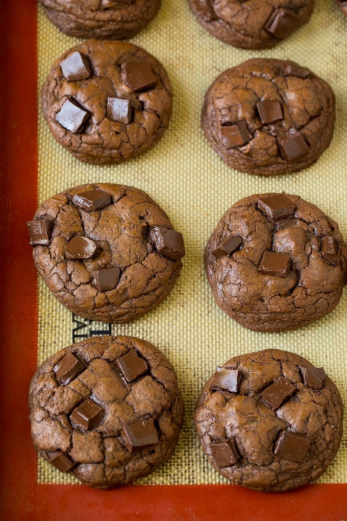 Baked chocolate cookies on a sheet pan.