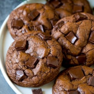 Brownie cookies on a serving plate, topped with chocolate chunks.