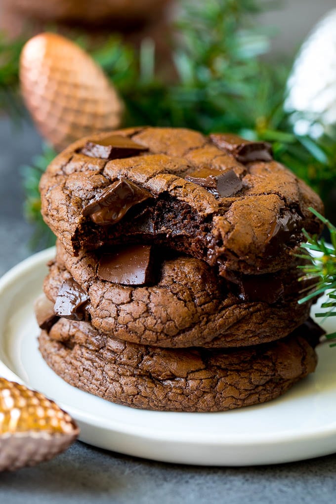 A stack of brownie cookies with a bite taken out of one.