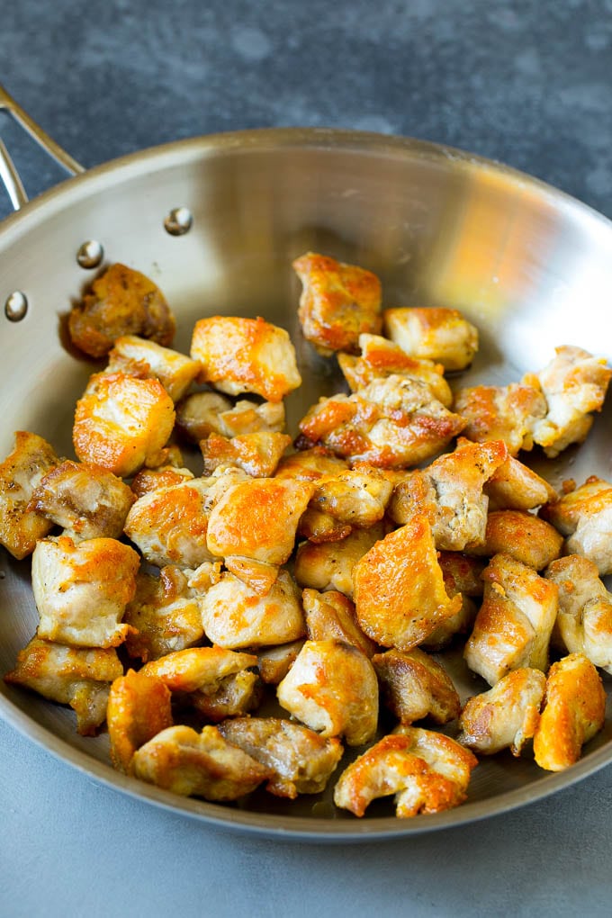 Browned chicken pieces in a skillet.