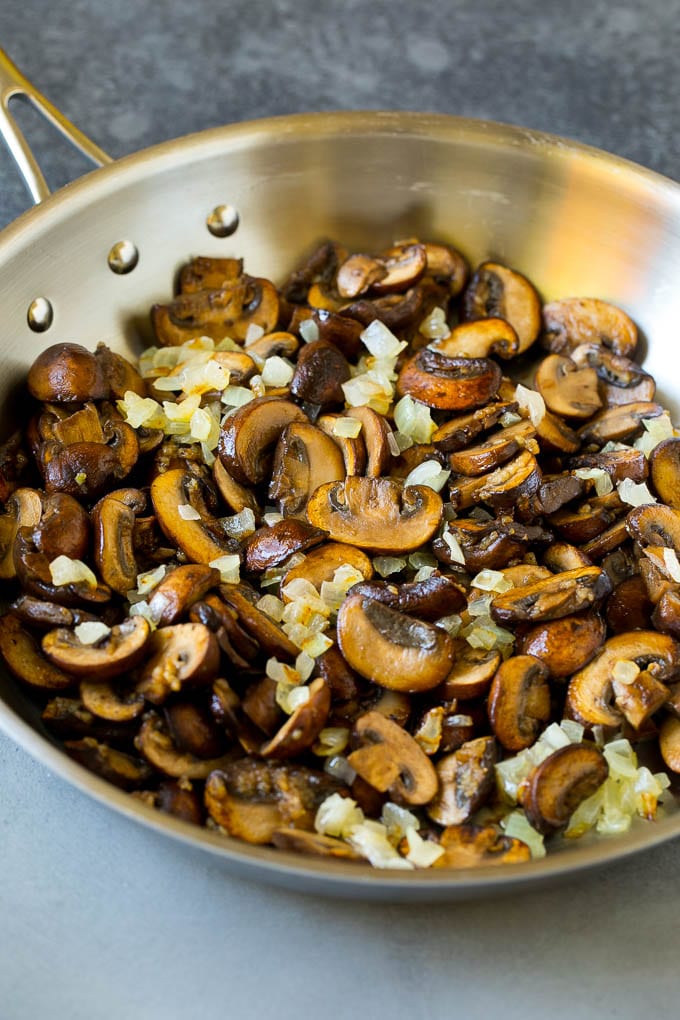 Sauteed mushrooms and onions in a skillet.