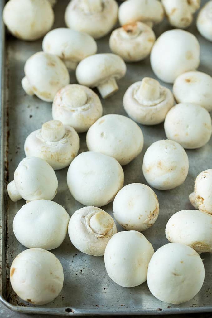 White button mushrooms on a sheet pan.