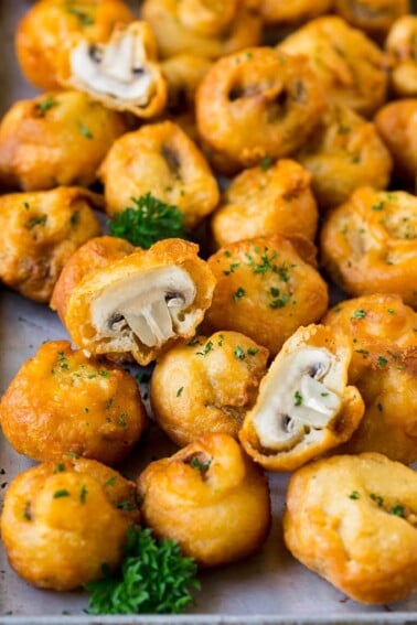 A sheet pan of fried mushrooms garnished with parsley.