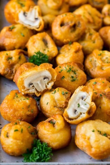 A sheet pan of fried mushrooms garnished with parsley.