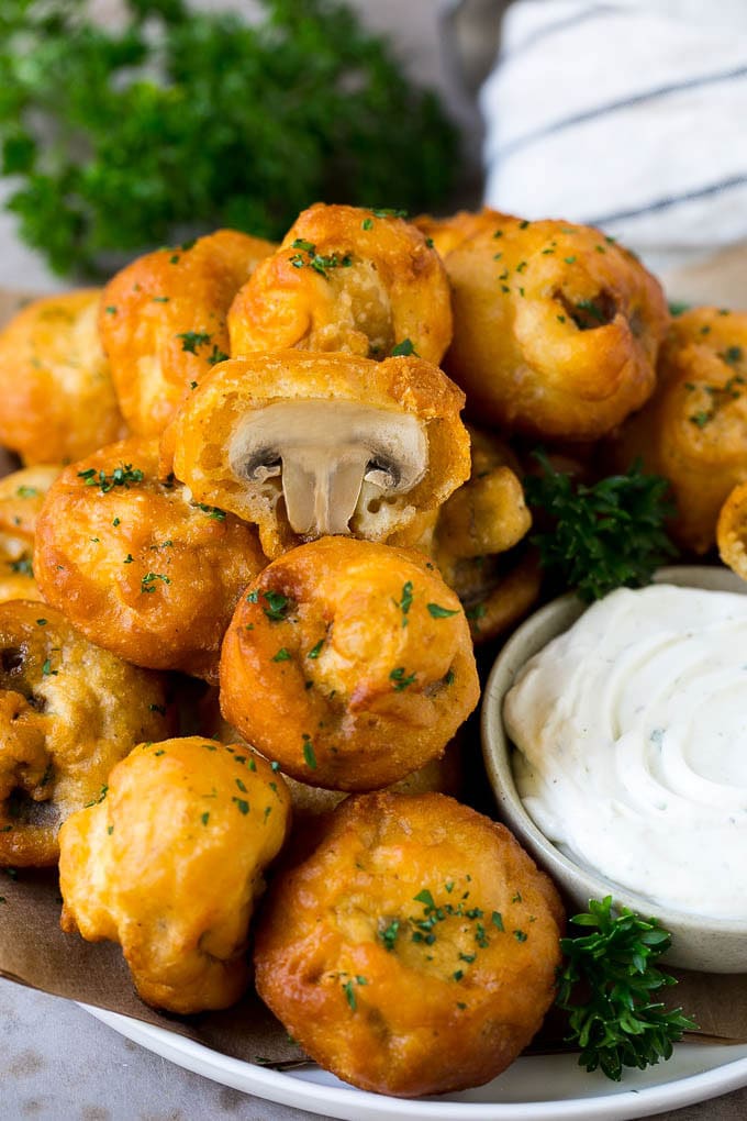 A plate of fried mushrooms served with ranch dip.