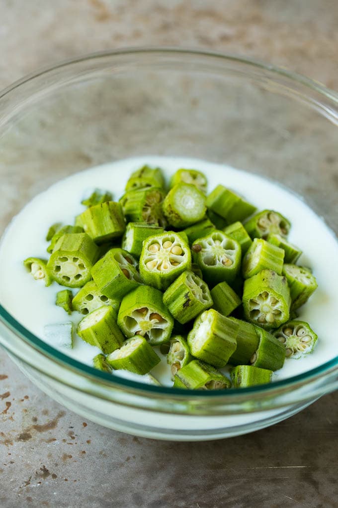 Sliced okra in a bowl of buttermilk.