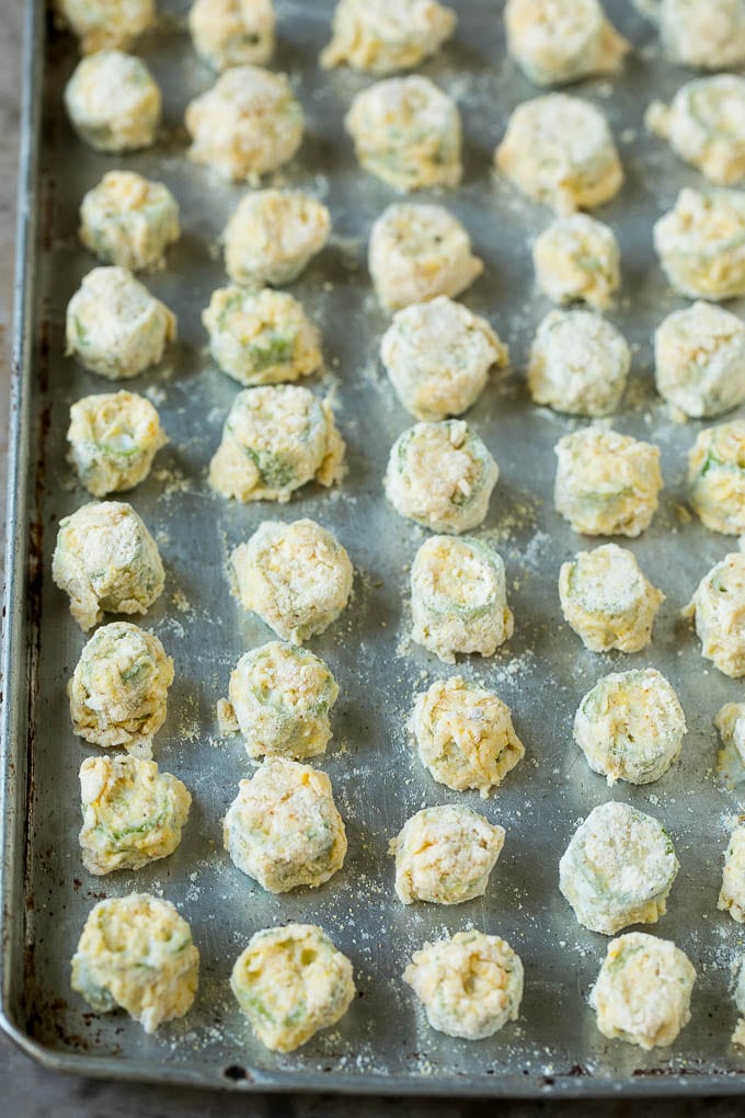 Breaded okra slices on a sheet pan.