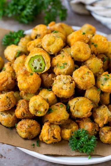 A serving plate of fried okra garnished with parsley.