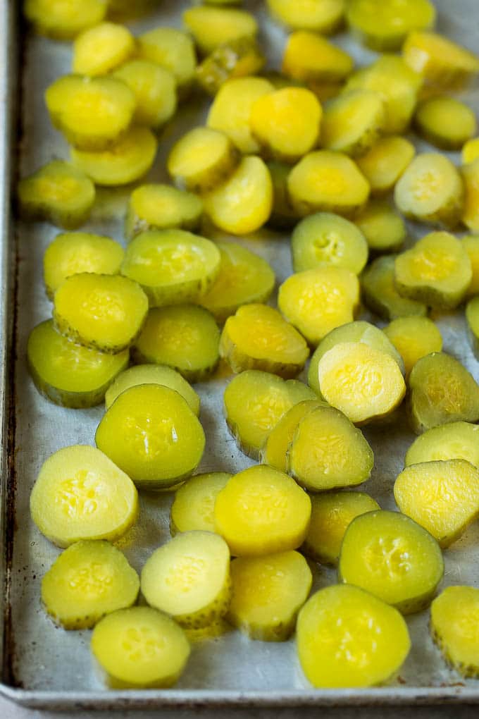 Sliced dills on a sheet pan.