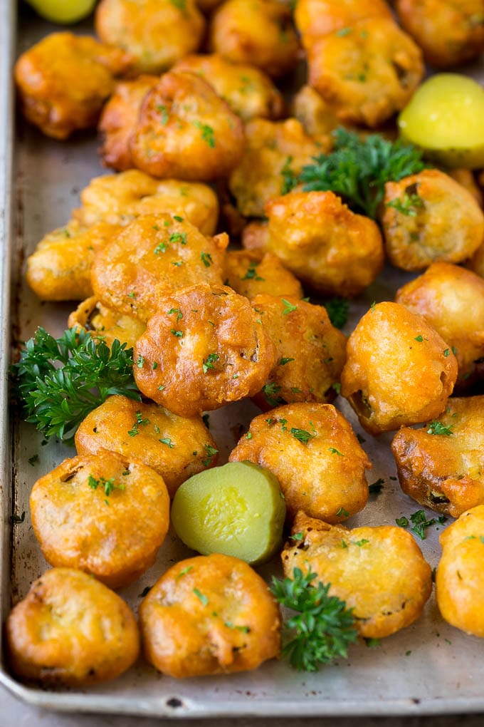 Fried Pickles Recipe #pickles #appetizer #snack #dinneratthezoo Fried pickles on a sheet pan, garnished with parsley.