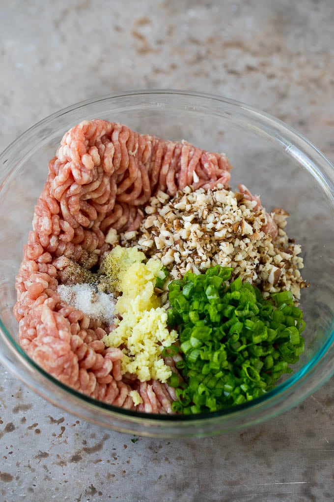 Ground pork with diced mushrooms and seasonings in a mixing bowl.