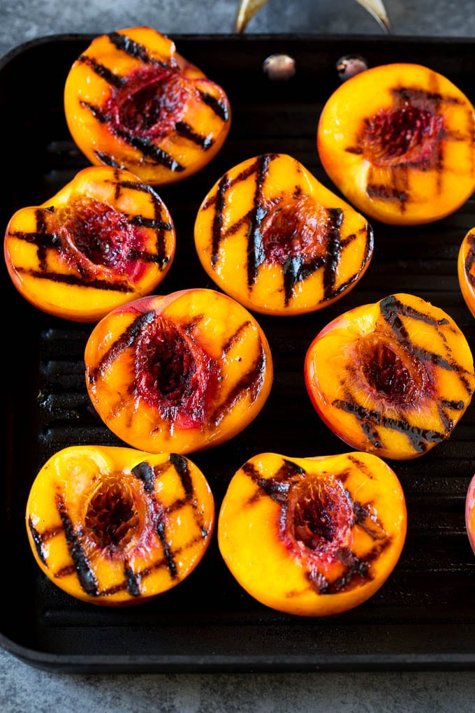 Peach halves cooked on a grill pan.