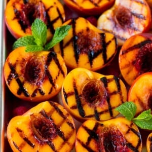 Grilled peaches garnished with raspberries and fresh mint.