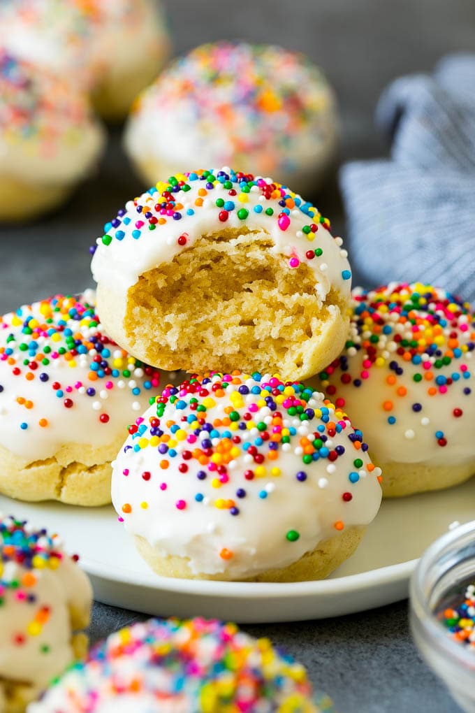 A plate of Italian cookies with a bite taken out of one.